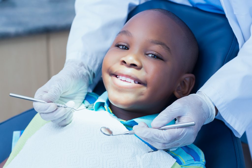 Young boy at the dentist smiling.